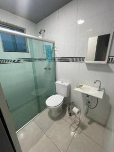a bathroom with a toilet and a shower and a sink at Casa confortável p/13/14/18 pessoas c 4/5/6 suítes in Belo Horizonte