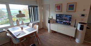 a living room with a television and a table and chairs at Komfortabler Bungalow, Husen 15 , 2 bis 4 Personen, Europa-Feriendorf in Husen