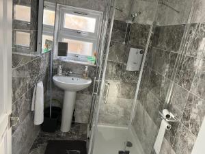 uma casa de banho com um chuveiro, um lavatório e um WC. em Remarkable 1-Bed Outhouse Studio in Dagenham em Dagenham