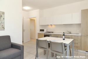 una cucina e una sala da pranzo con tavolo e sedie di 3V apartments Bardolino a Bardolino