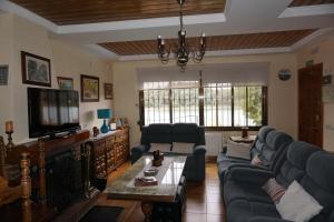 a living room with a couch and a tv at Casa Rural Noel en Parque Natural Lagunas de Ruidera in Ossa de Montiel