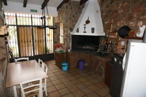 cocina con chimenea, mesa y sillas en Casa Rural Noel en Parque Natural Lagunas de Ruidera en Ossa de Montiel
