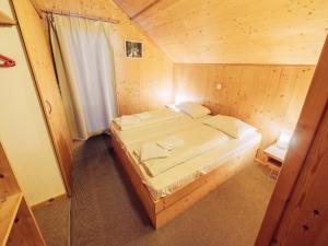 1 dormitorio con 1 cama en una cabaña de madera en Woody 9, en Sankt Lorenzen ob Murau