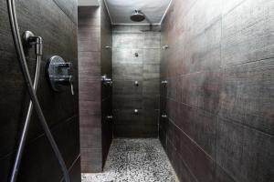 a bathroom with a walk in shower and a tile floor at Zefnea House in Catania