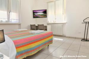 una camera con un letto con una coperta colorata di 3V apartments Bardolino a Bardolino