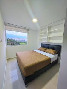 a bedroom with a large bed with a window at Apartamento en Ibagué - parque deportivo in Ibagué