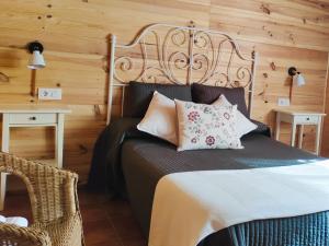 a bedroom with a bed with a wooden wall at Casa Rural La Dehesa de Toledo a 5 minutos de Puy du Fou España in Cobisa