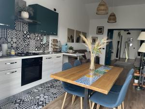 cocina con mesa de madera y sillas azules en Loft panoramico Caltagirone centro en Caltagirone