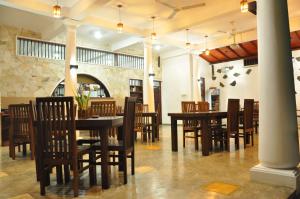 a dining room with wooden tables and chairs at Fort Edge Retreat in Unawatuna