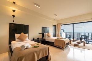 a hotel room with two beds and a balcony at Samaya Wellness Resort in Lamai