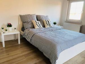 a bedroom with a bed with striped sheets and pillows at Ihr Zimmer in Freital bei Dresden in Freital