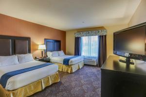 um quarto de hotel com duas camas e uma televisão de ecrã plano em Holiday Inn Express Hotel & Suites Huntsville, an IHG Hotel em Huntsville
