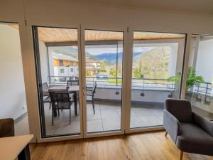 a living room with sliding glass doors with a table and chairs at Kreischberg The Exclusive 6 in Sankt Lorenzen ob Murau