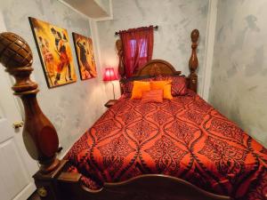 a bedroom with a red bed with orange pillows at The vampire's den, downtown big house, pets ok in Fort Smith
