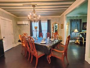 a dining room with a table with chairs and a chandelier at The vampire's den, downtown big house, pets ok in Fort Smith