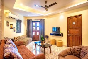 uma sala de estar com um sofá e uma televisão em 'Golden Sunset' 3bhk beach villa em Benaulim