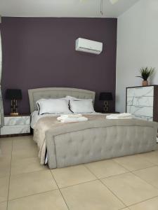 a bedroom with a large bed with a couch at Kato Paphos 2 Bedroom House - Tourist location in Paphos City