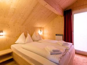 uma cama grande num quarto com tecto em madeira em Murau 11 em Murau