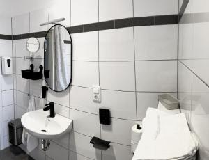uma casa de banho branca com um lavatório e um espelho em Serviced Room im Herzen Berlin‘s em Berlim