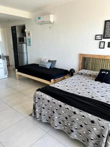 a bedroom with two beds and a refrigerator at El Porteño in San Pedro