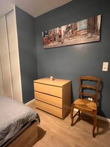 ein Schlafzimmer mit einem Bett, einer Kommode und einem Stuhl in der Unterkunft Joli T2 - 4P Bien équipé - Palaiseau Massy Orly in Palaiseau