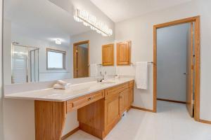 a bathroom with a sink and a large mirror at Coral Springs Lakefront Retreat in Calgary +65 photos