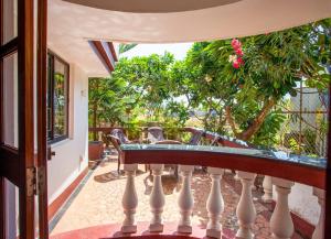 uma varanda de uma casa com uma mesa e cadeiras em 'Golden Sunset' 3bhk beach villa em Benaulim