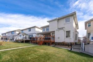 a house with a porch and a yard with houses at Coral Springs Lakefront Retreat in Calgary