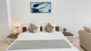 a bedroom with a white bed and a couch at Wadi Shab Beach Villa in Sur