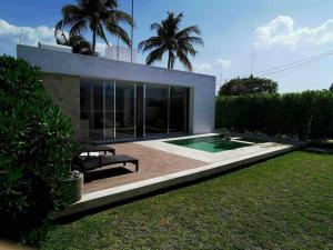 a house with a swimming pool in a yard at Casa Kay - 1 in Sisal