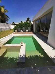 a house with a green pool in front of it at Casa Kay - 1 in Sisal +13 photos