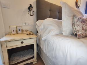 1 dormitorio con 1 cama y mesita de noche junto a la cama en Reguero Gato, Apartamentos Rurales 3 llaves en Candamo