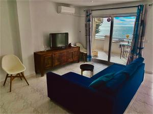 a living room with a blue couch and a tv at Increíbles vistas al Mar in Cabo de Palos