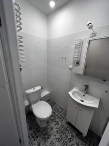 a white bathroom with a toilet and a sink at Lodging Młyńska Parking free in Bielsko-Biała