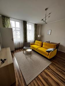 a living room with a yellow couch and a rug at Lodging Młyńska Parking free in Bielsko-Biała