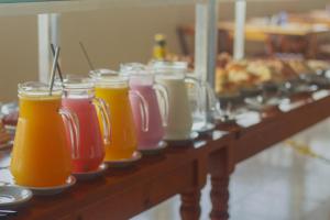 a row of bottles of juice on a table at Pousada Costa da Riviera in Bertioga