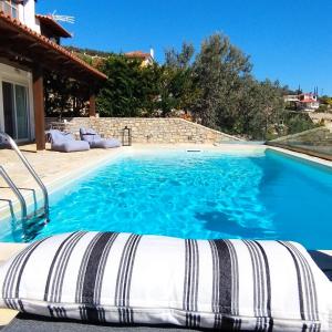 a large swimming pool with blue water at Apollo Romantic Sea View Villa in Kiveri