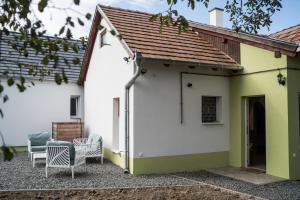 een wit en groen huis met twee stoelen bij Csipesz_Vendégház in Sümeg