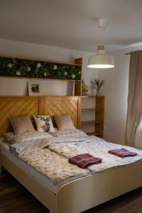 1 dormitorio con 1 cama grande y cabecero de madera en Csipesz_Vendégház, en Sümeg