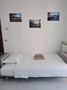 łóżko w pokoju z trzema zdjęciami na ścianie w obiekcie Casa Amelia lago Maggiore w mieście Maccagno Inferiore
