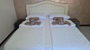 two beds with white sheets and towels on them at Casa Amelia lago Maggiore in Maccagno Inferiore