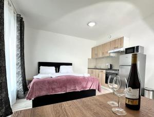 a bedroom with a bed and a bottle of wine on a table at Sky Apartments 503 in Pilsen