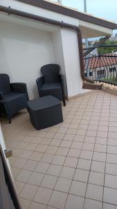 a patio with two chairs and a table on a balcony at B&B "LE LUCI" SUPER CAMERA IN ATTICO interno 3 in Vasto