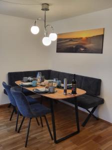 mesa de comedor con sillas azules y sofá en Ferienhaus Sonnenblick Schmilka, en Schmilka