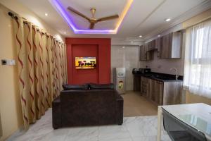 een woonkamer met een bank en een keuken bij Impeccable 1-Bedroom Furnished Apartment in Accra in Accra