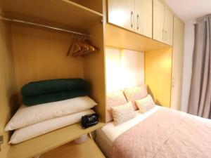 Habitación pequeña con cama y algunas almohadas en Sweet Home Sudoeste - Completo e aconchegante en Brasilia