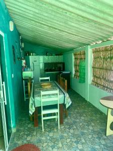 Pokój ze stołem i krzesłami w kuchni w obiekcie Casa da Clau w mieście Cananéia
