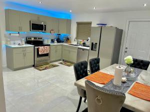 a kitchen with a table and chairs and a refrigerator at New Air VACATION FUN in Pompano Beach