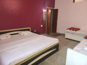 una camera con un grande letto e una parete viola di Junglee Nest Holiday Home a Mahabaleshwar