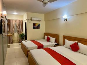 Habitación de hotel con 2 camas y baño en Hotel Rooms DHA en Karachi